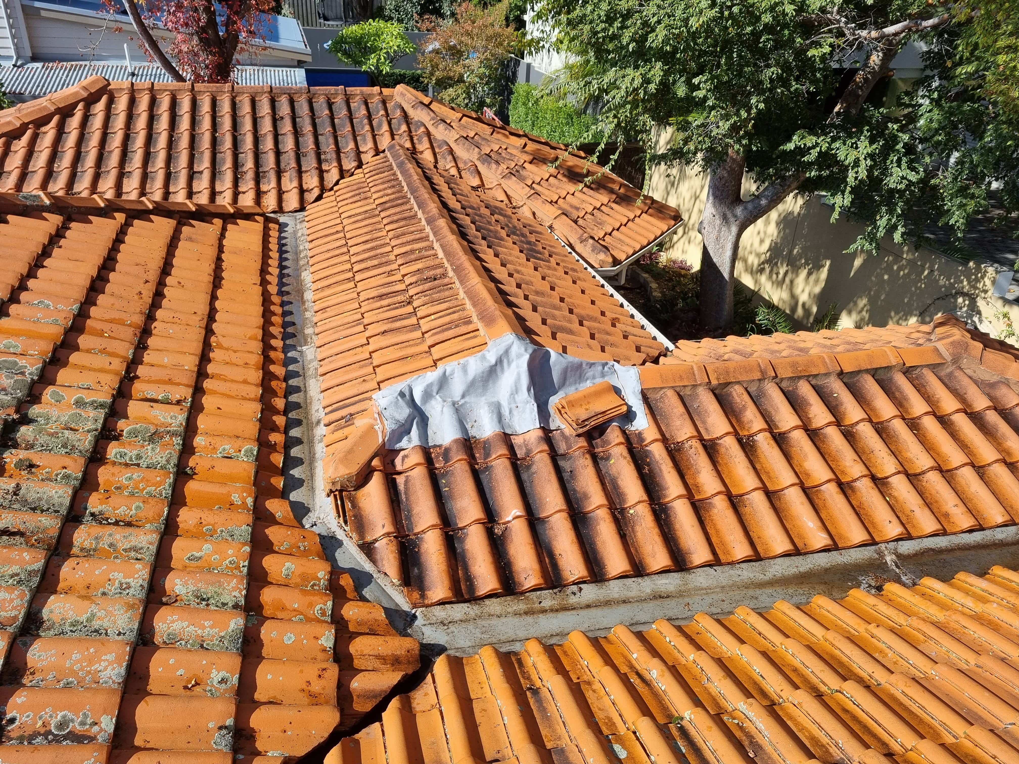 A roof featuring vibrant orange tiles alongside a contrasting white section.